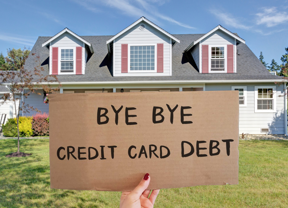 Hero image of a hand holding a sign that says 'No monthly payments ever' in front of a house